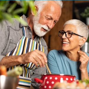 older couple cooking and smiling