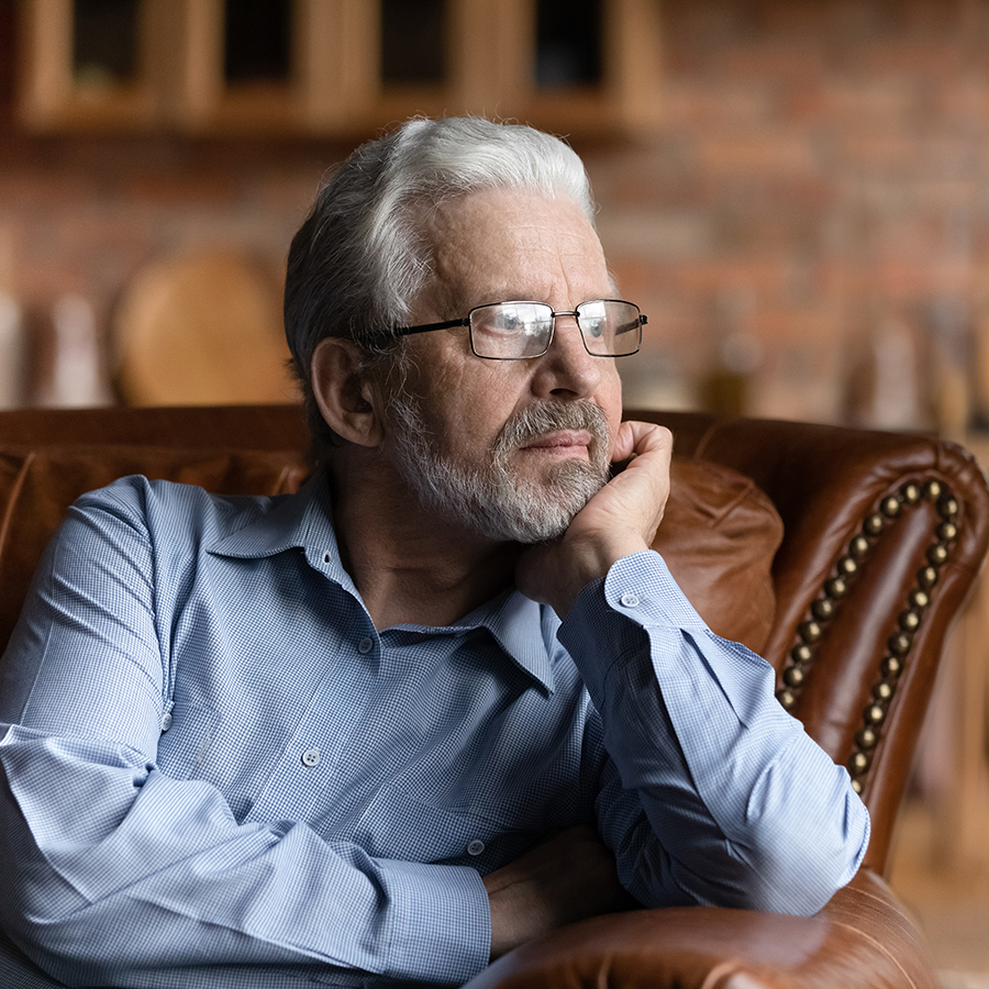 Image of a depressed man looking out the window.